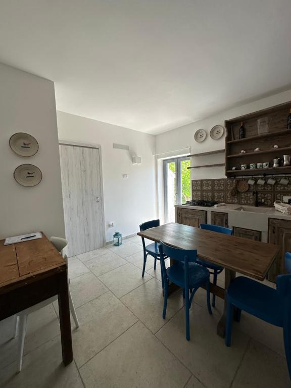 une cuisine avec une table en bois et des chaises bleues dans l'établissement Trulli Conca d oro La lamia, à Martina Franca