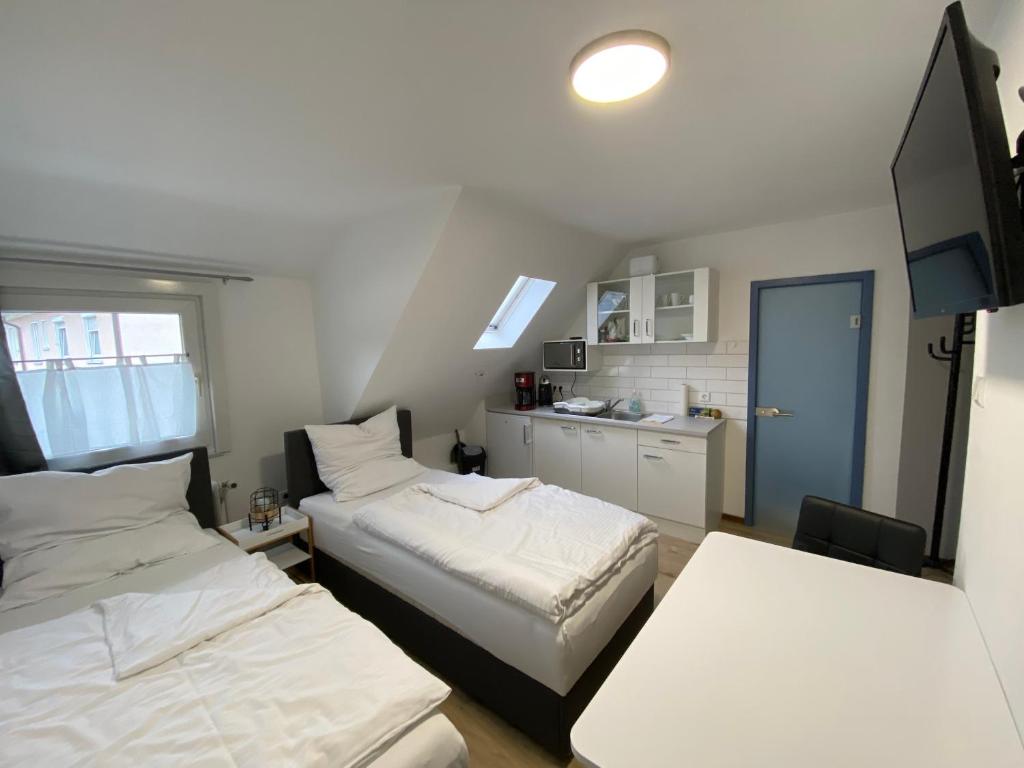 Habitación pequeña con 2 camas y cocina en Apartment Q im Zentrum von Königsbronn en Königsbronn
