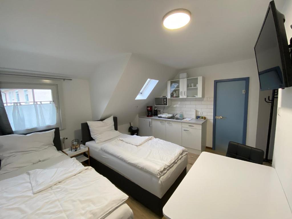 a small room with two beds and a kitchen at Apartment Q im Zentrum von Königsbronn Monteurzimmer in Königsbronn