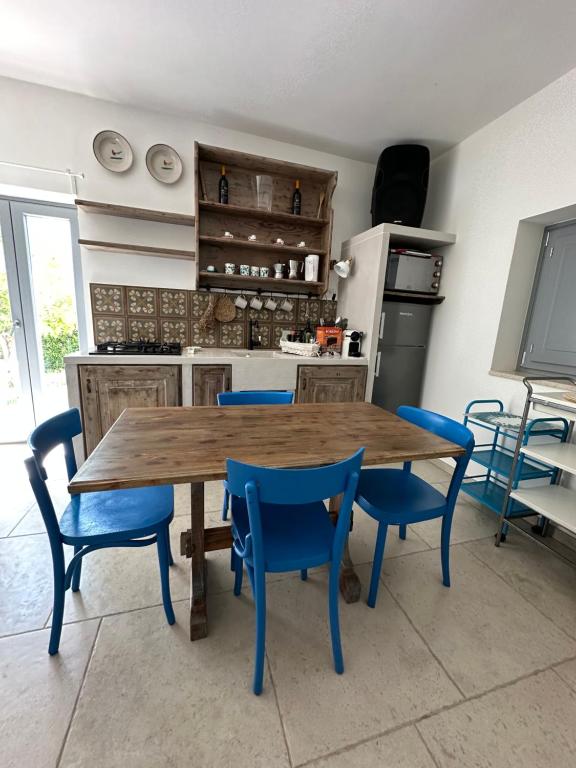 une cuisine avec une table en bois et des chaises bleues dans l'établissement Trulli Conca d oro La lamia, à Martina Franca 16 autres photos