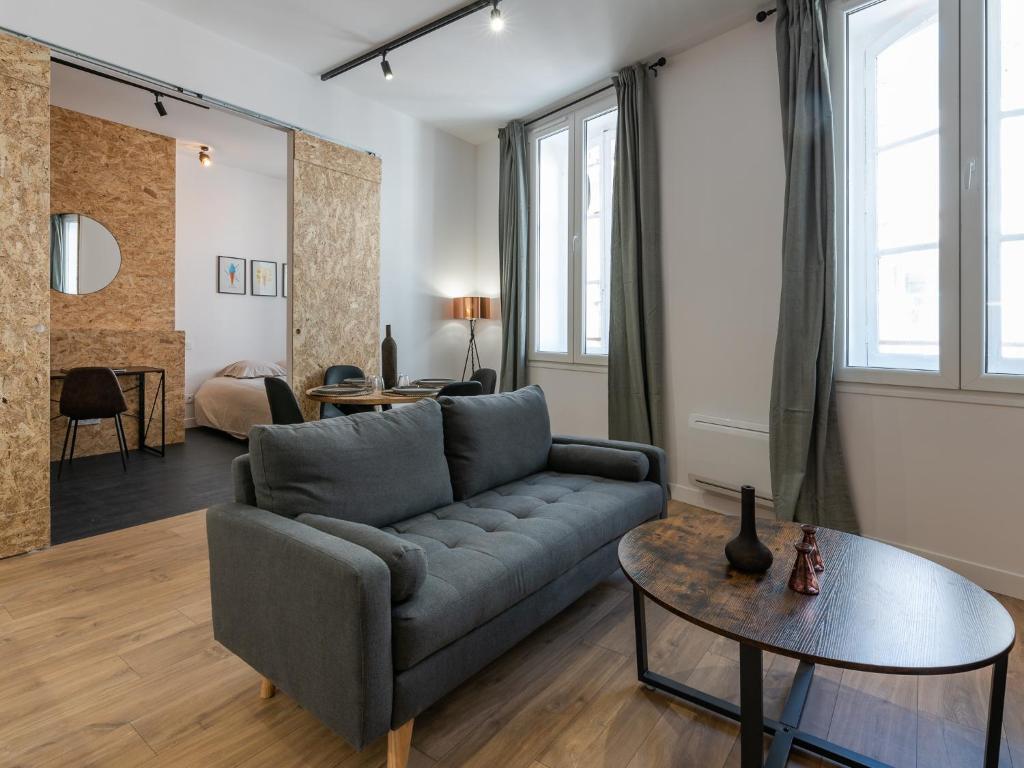 a living room with a couch and a table at L'Escapade Roannaise in Roanne