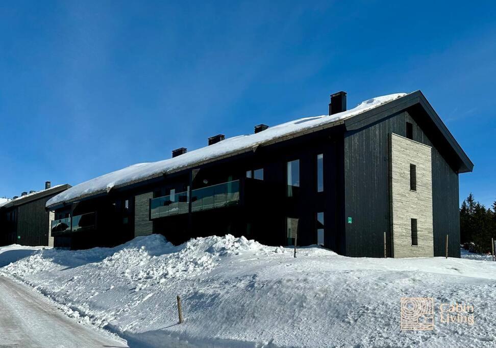 um edifício com uma pilha de neve à sua frente em New apartment Hafjelltoppen ski inout em Hafjell