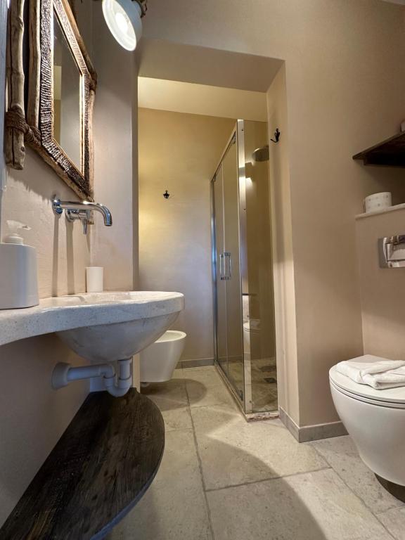 une salle de bains avec lavabo et toilettes dans l'établissement Trulli Conca d oro La lamia, à Martina Franca