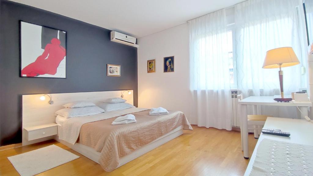 um quarto com uma cama branca e uma parede azul em Central point em Zagreb