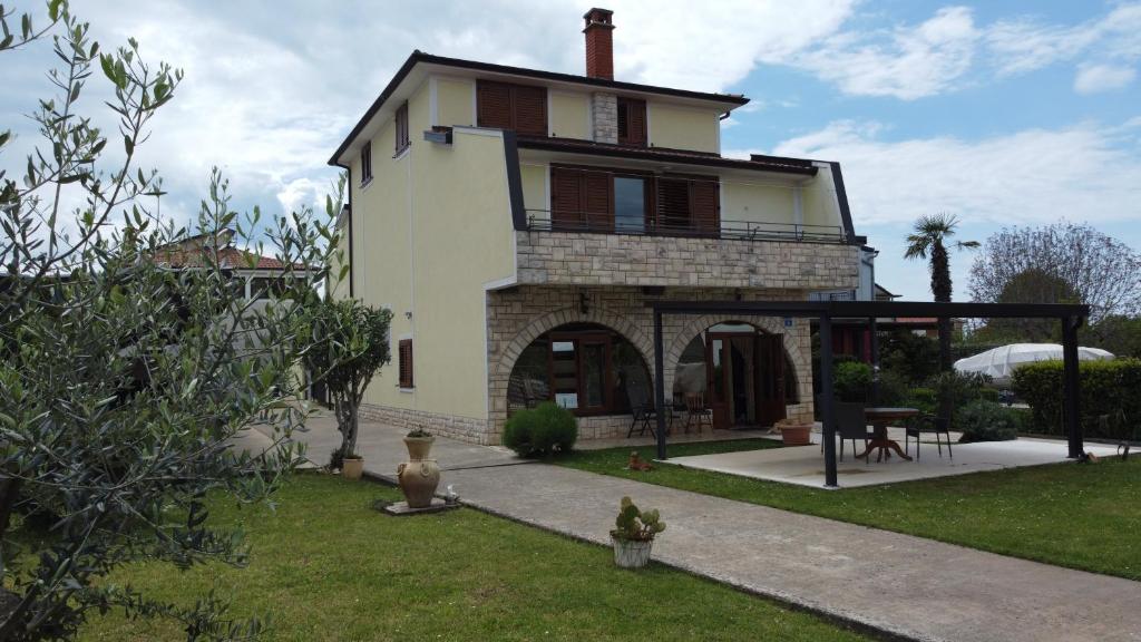 a large house with a porch and a patio at Apartments Krnjic in Umag