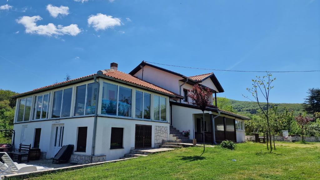 ein großes weißes Haus mit großen Fenstern auf einem Feld in der Unterkunft Meriland Kosmaj in Nemenikuće