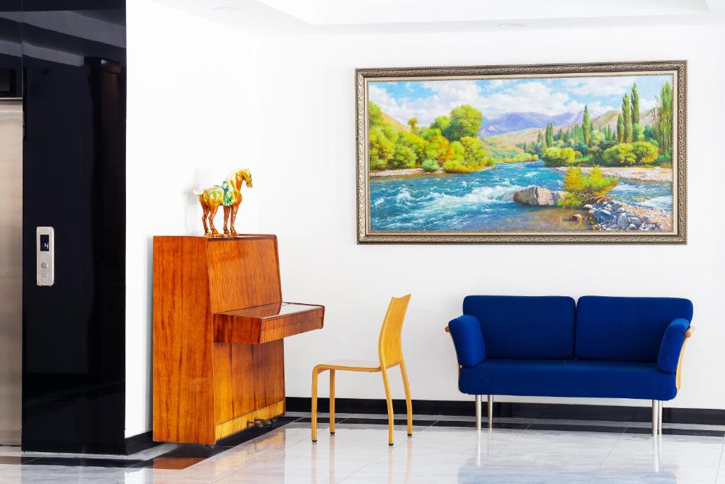 salon z niebieskim krzesłem i obrazem w obiekcie CENTRAL ASİA HOTEL w Taszkiencie