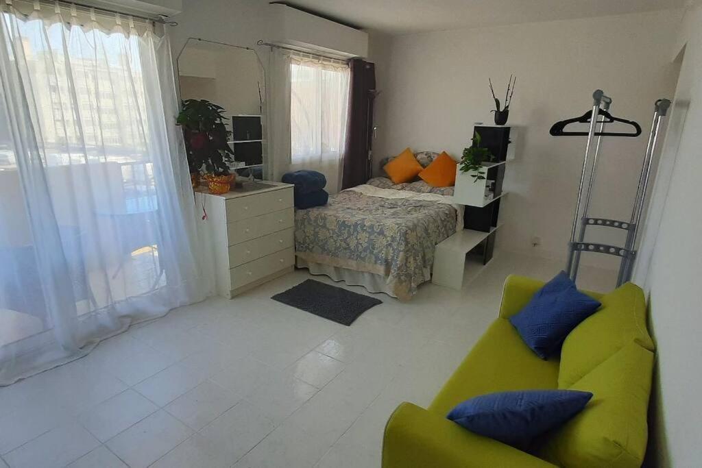- une chambre avec un lit et un canapé jaune dans l'établissement Studio cosy à Nice, à Nice
