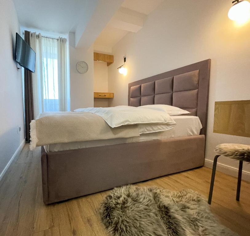 a bedroom with a large bed and a rug at Twins in Suceava