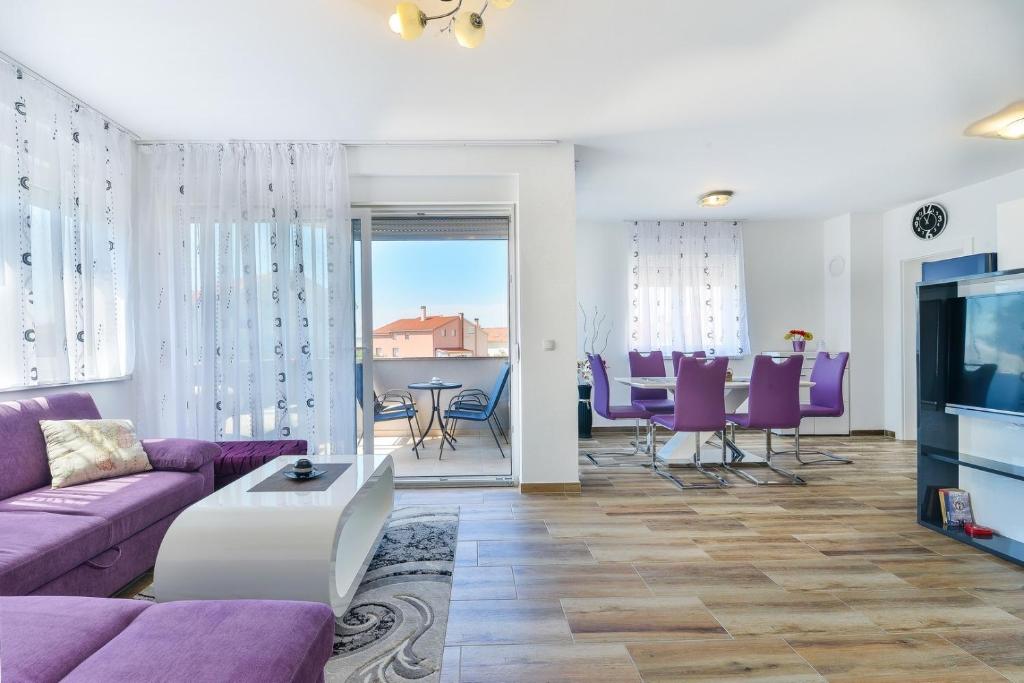 salon z fioletową kanapą i stołem w obiekcie Apartment South w mieście Zadar