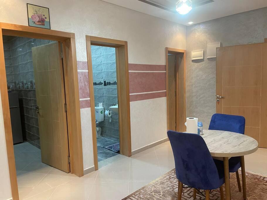 a room with a table and chairs and a bathroom at LH résidence mezouar1 appartement 4 in Laayoune