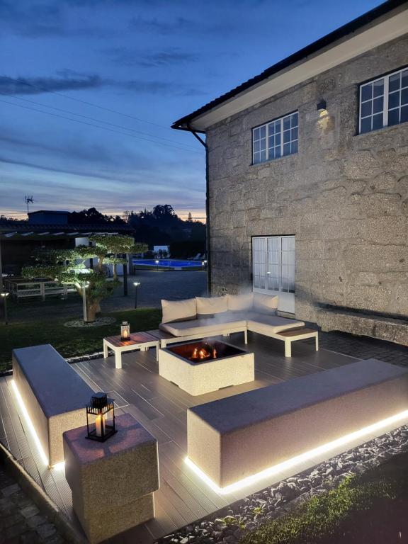 um pátio com sofás e uma fogueira em frente a um edifício em Villa Moura - Pool & Jacuzzi em Póvoa de Lanhoso