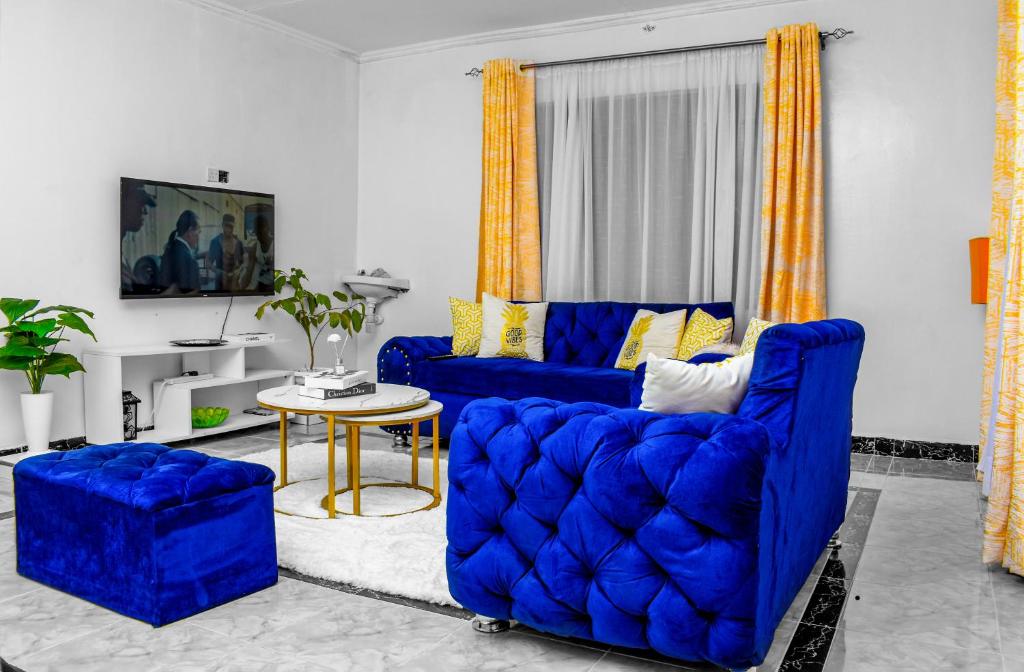 a living room with blue couches and a table at Sparkle Homes 