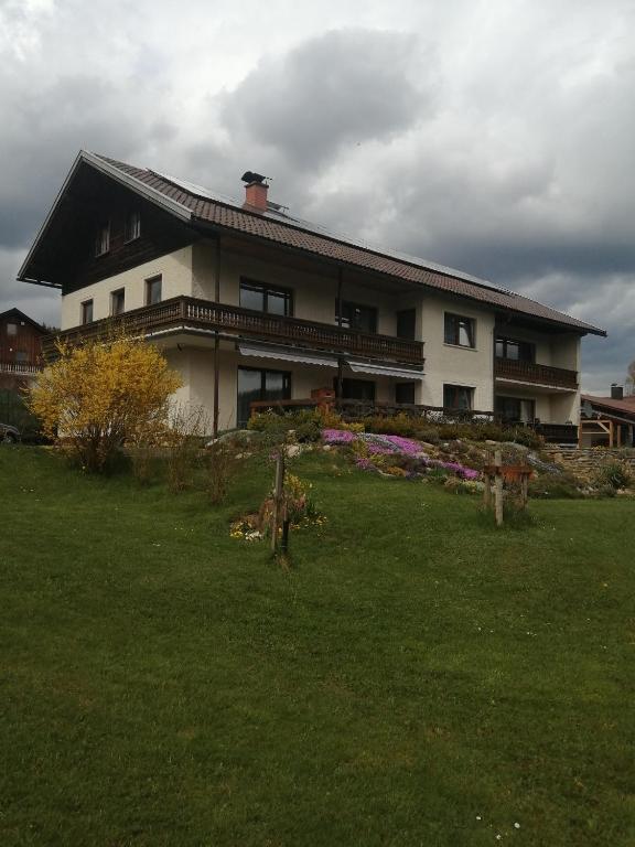 a large house with a green yard in front of it at Wohnung Martha in Bayerisch Eisenstein