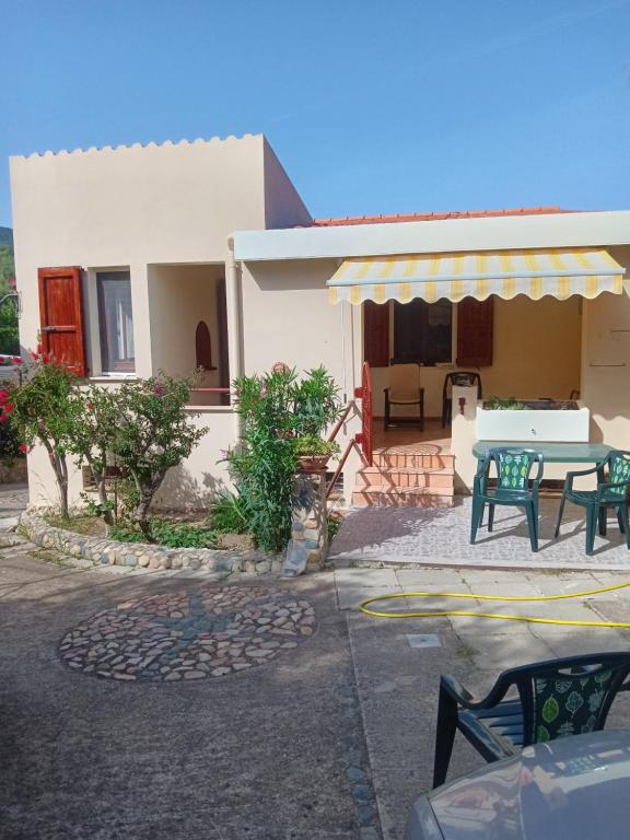 a house with a patio with a table and chairs at Vacanze a Solanas.....con Clima in Solanas