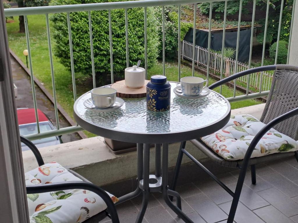 a table with two cups and two chairs on a porch at VALTELLINA SONDRIO HOLIDAYS in Sondrio