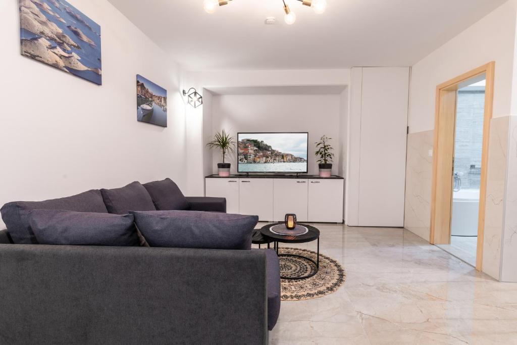 ein Wohnzimmer mit einem Sofa und einem TV in der Unterkunft Apartments Bonis III in Šibenik