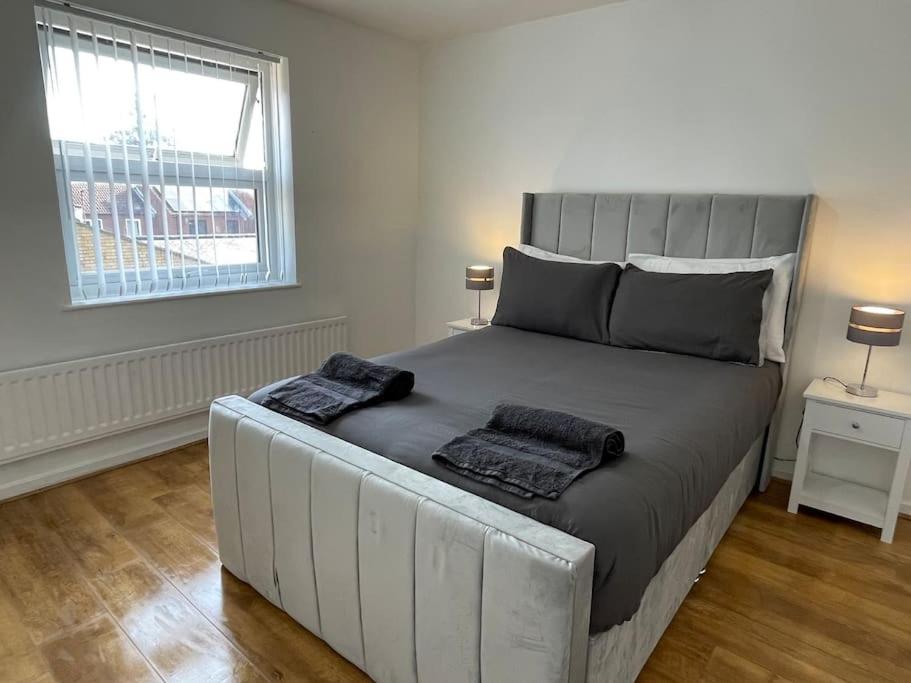 sypialnia z dużym łóżkiem z 2 poduszkami w obiekcie NEW! 4 Bedroom London House with Garden and Lawn w Londynie