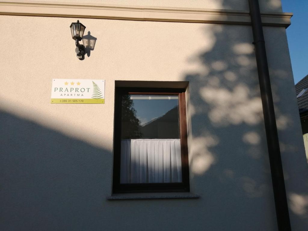 Una ventana de un edificio con un cartel. en Apartma Praprot en Mojstrana