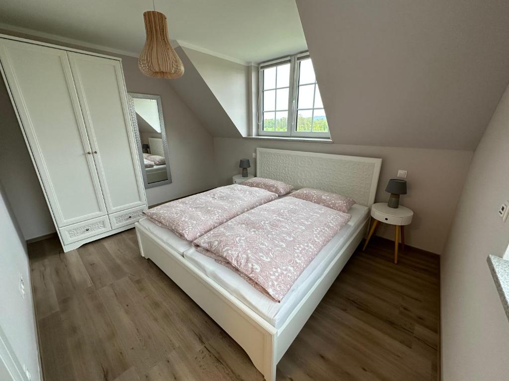 een slaapkamer met een groot bed met roze lakens bij Ferienwohnung Oberförstchen in Göda