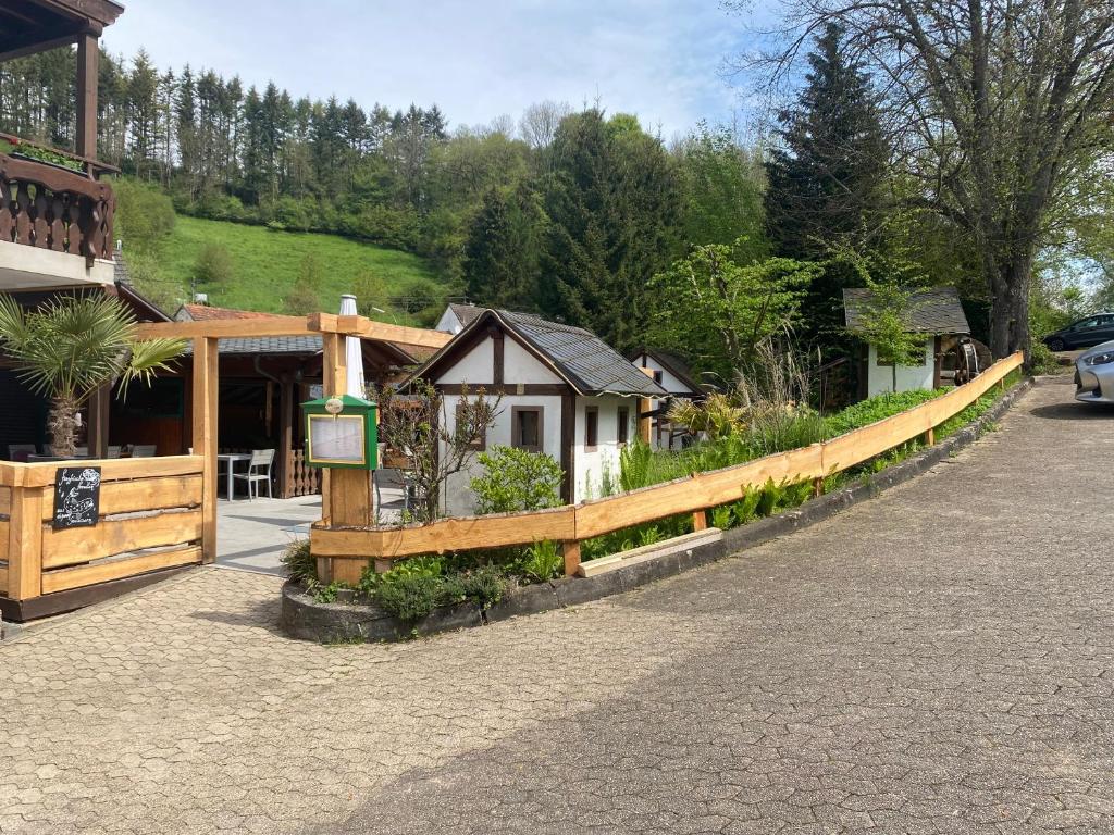 a wooden fence in front of a building at Hotel-Restaurant Theis-Muehle in Biersdorf