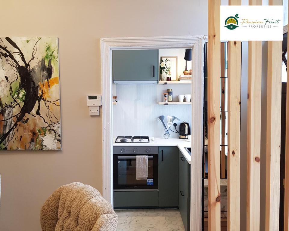 uma pequena cozinha com um fogão e um lavatório em 2 Bedroom House In Leeds With Free Wi-Fi and Parking 24 WAL em Beeston Hill