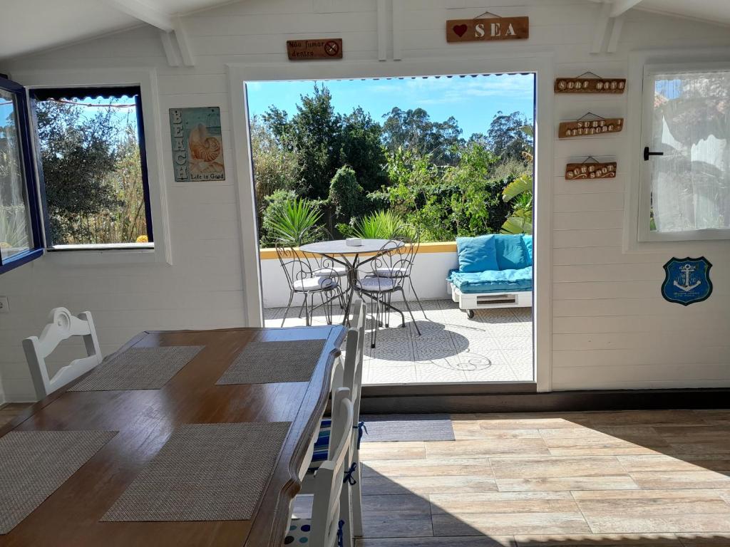 a dining room with a table and chairs and a patio at Casa Lantana in Figueira da Foz