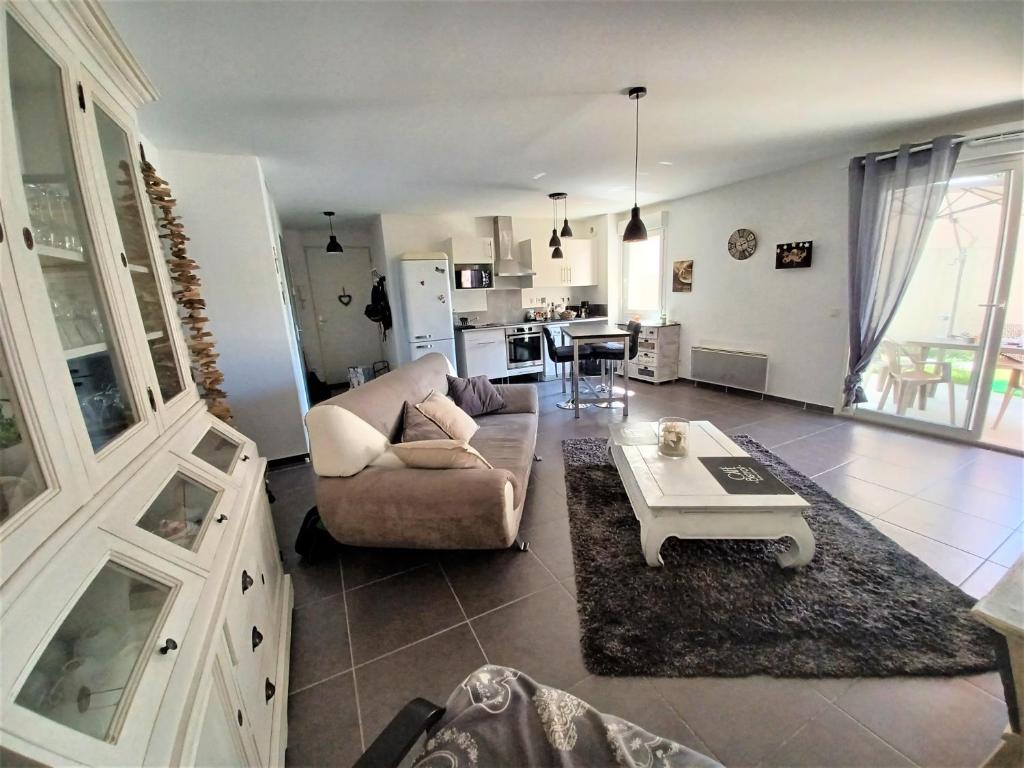 un salon avec un canapé et une table dans l'établissement L'isle sur la sorgue, appartement 2 pièces jardin parking, à LʼIsle-sur-la-Sorgue