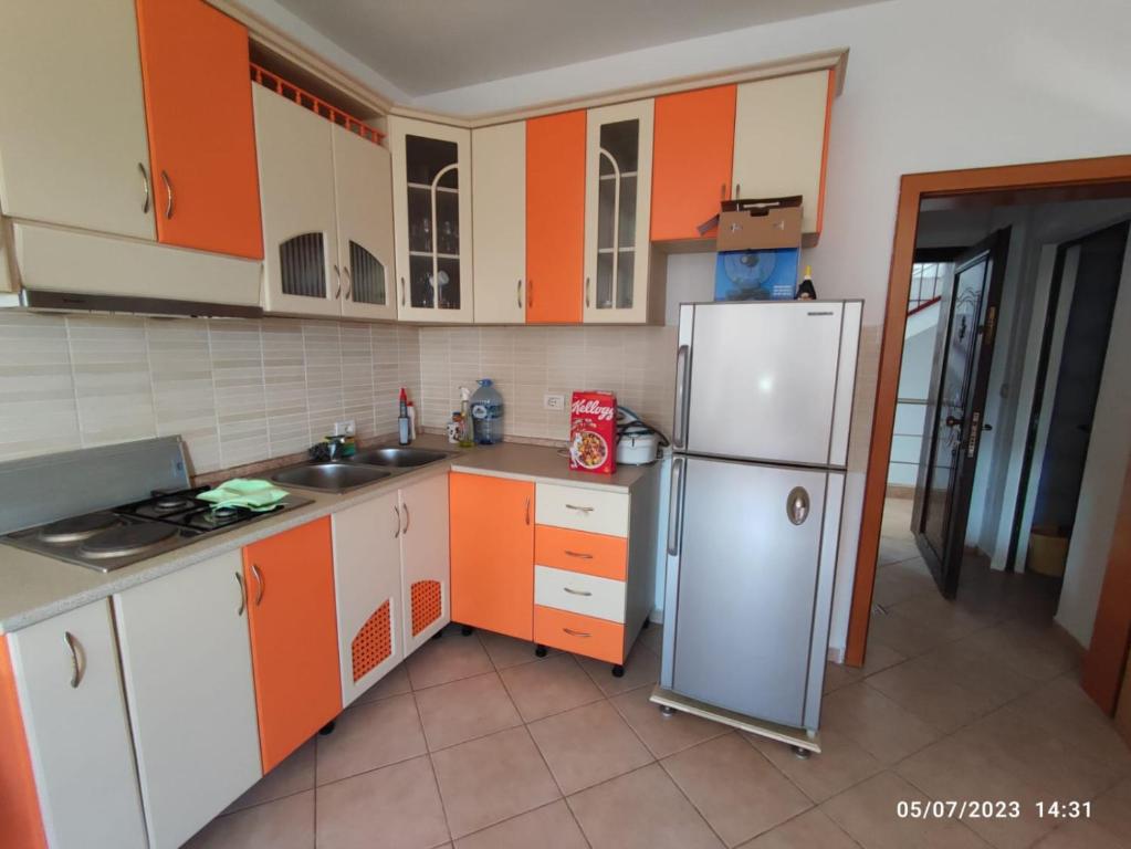 a kitchen with orange and white cabinets and a refrigerator at Mali robit golem durres apartment on 4th floor in Golem