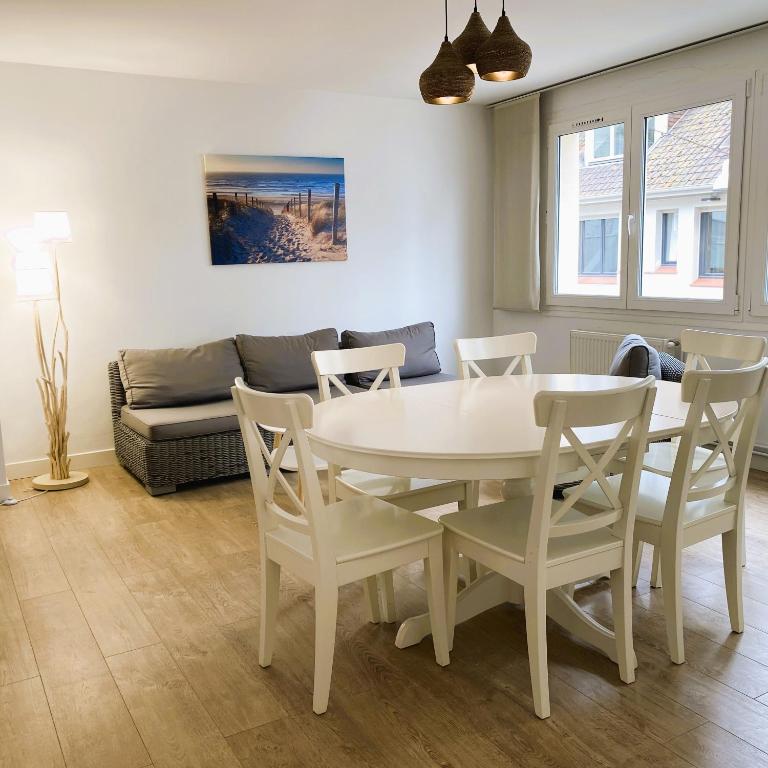 un salon avec une table, des chaises et un canapé dans l'établissement LA CARAVELLE T3 au cœur de ville proche de la plage, à Le Touquet-Paris-Plage