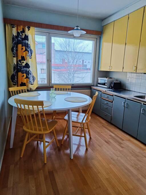 a kitchen with a table and chairs in a room at Iso kolmio, mahtavalla jokinäkymällä in Joensuu