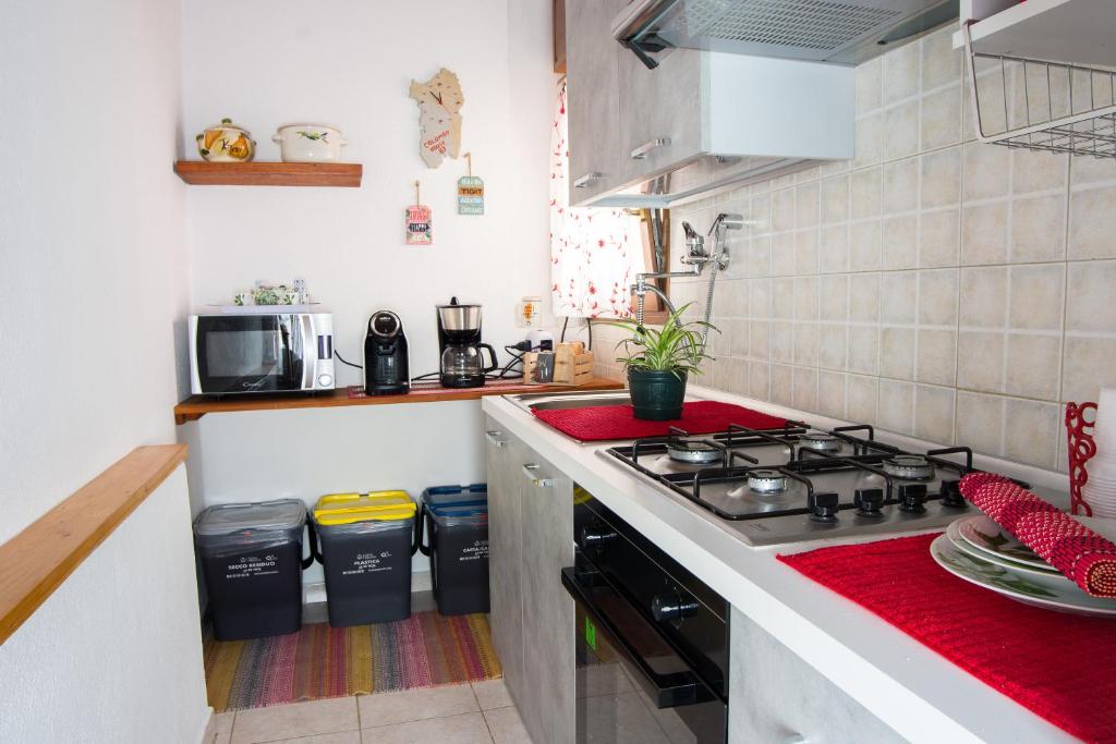 een keuken met een fornuis en wat vuilnisbakken bij Colombohouse87 in Quartu SantʼElena