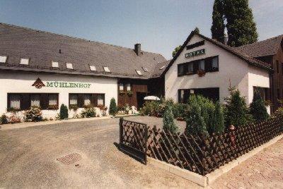 Ein weißes Gebäude mit einem Zaun davor. in der Unterkunft Hotel Mühlenhof in Heidenau