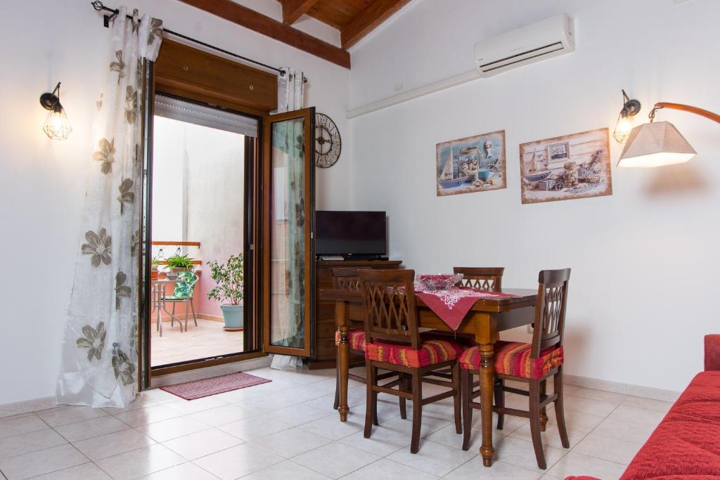 a dining room with a table and chairs and a television at Colombohouse87 in Quartu SantʼElena