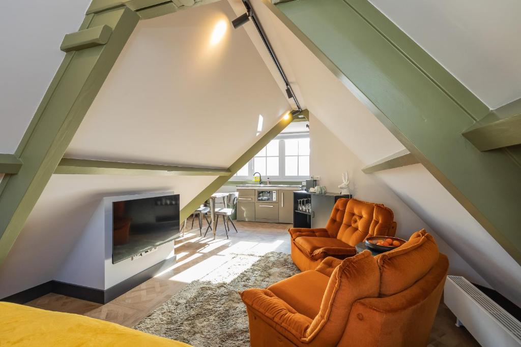 a living room with two chairs and a fireplace at Cottage Jacob in Zandvoort