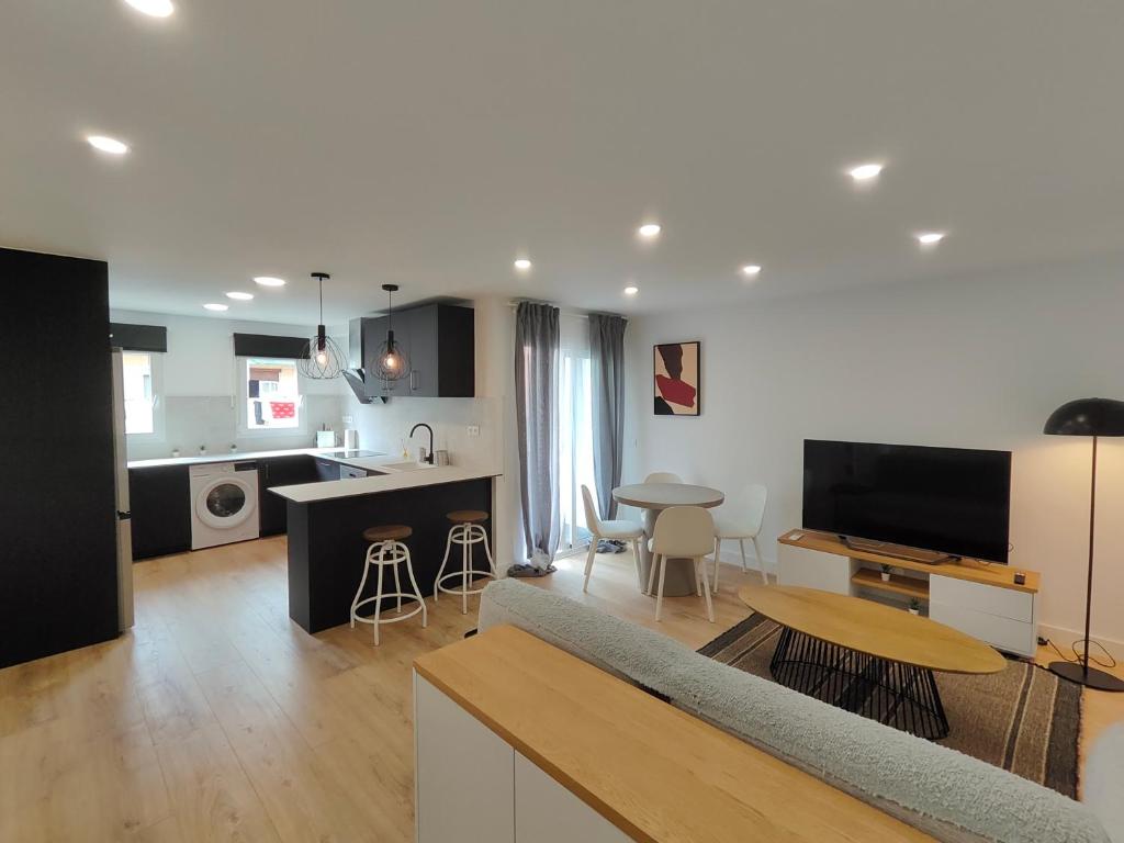 een woonkamer en een keuken met een bank en een tafel bij Fantastic apartment Sant Adria Beach in Sant Adria de Besos