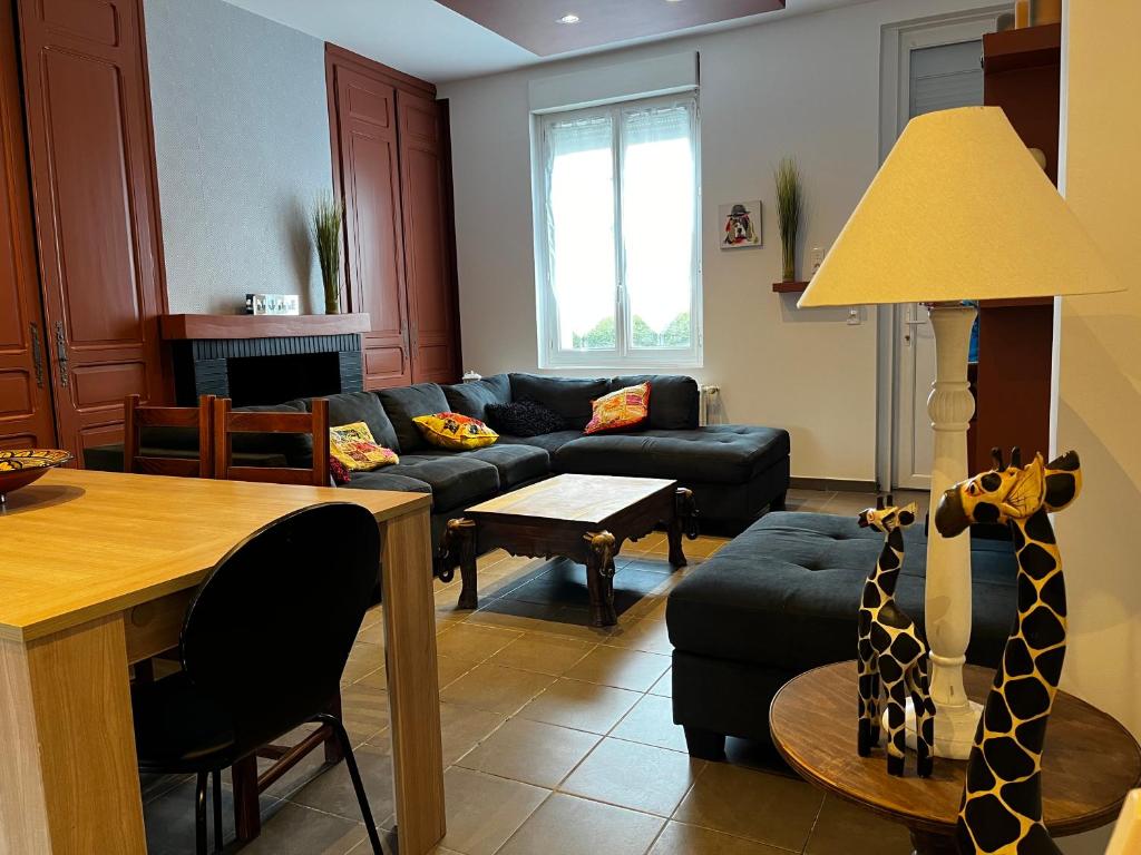a living room with a couch and a table with a giraffe statue at citesteloi in Friville-Escarbotin