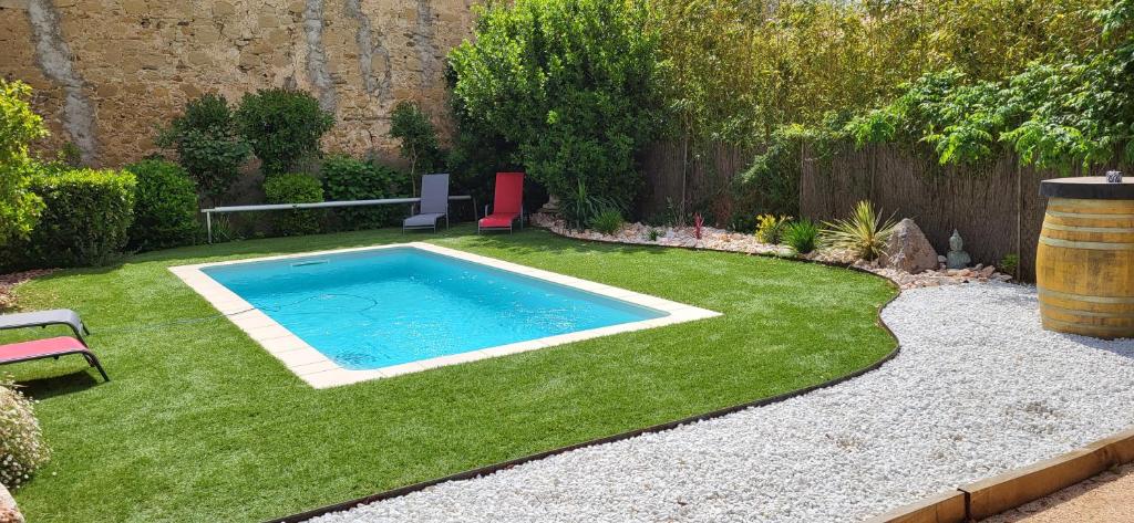 una pequeña piscina en un patio con césped en Chez mamie, en Bassan