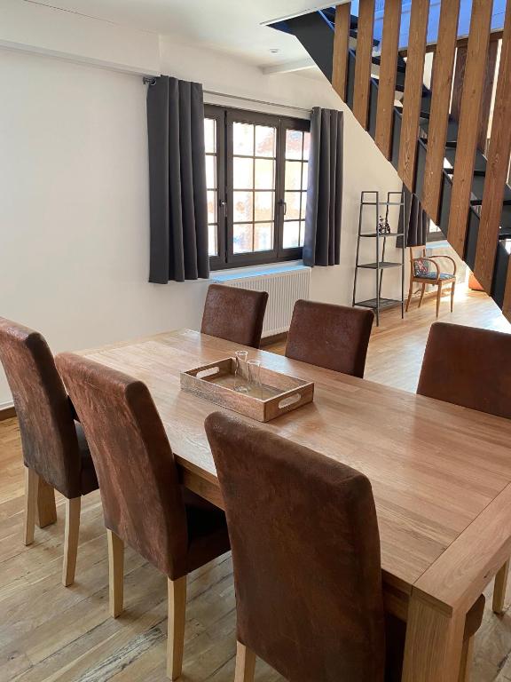 a dining room with a wooden table and chairs at Superbe appartement F4 au cœur de Malo-les-bains in Dunkerque