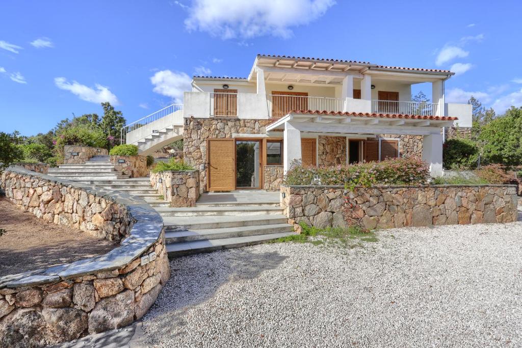 a house with a stone wall and stairs at La Perugina by DomusAway in Monte Petrosu