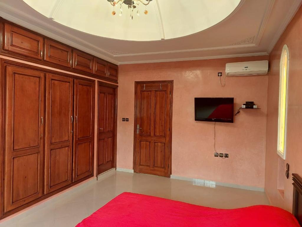 um quarto com um tapete vermelho e armários de madeira em Maison de charme em Tiznit