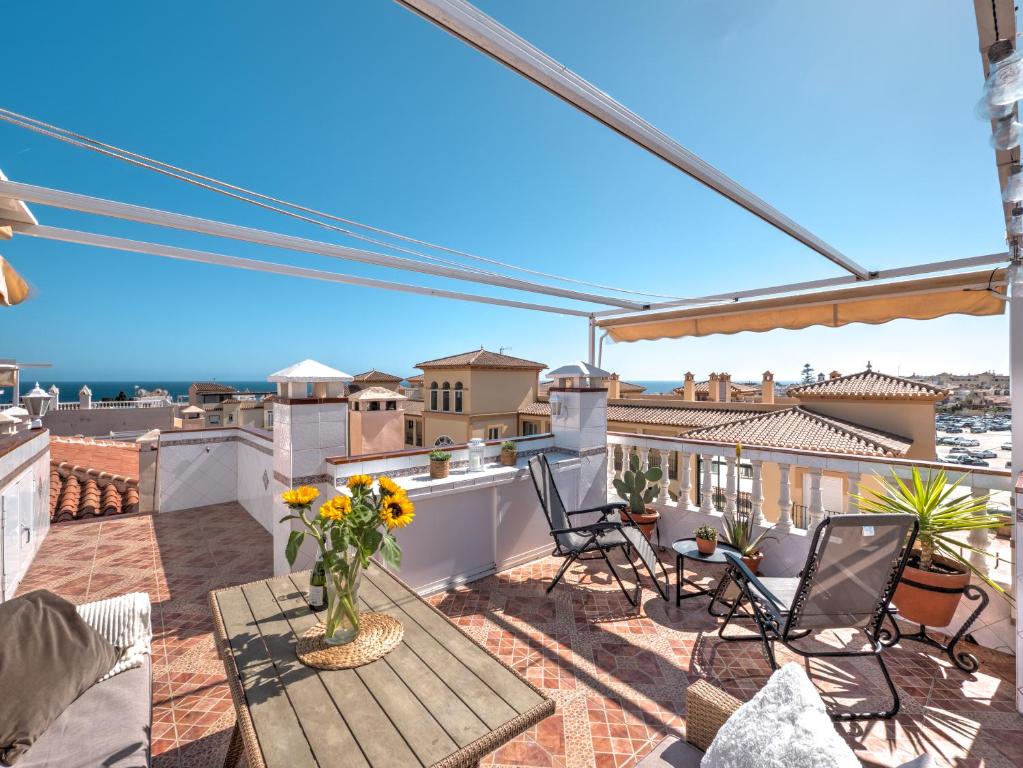 patio z krzesłami i stołem na dachu w obiekcie Fantastic penthouse with roof terrace in the heart of Nerja w mieście Nerja
