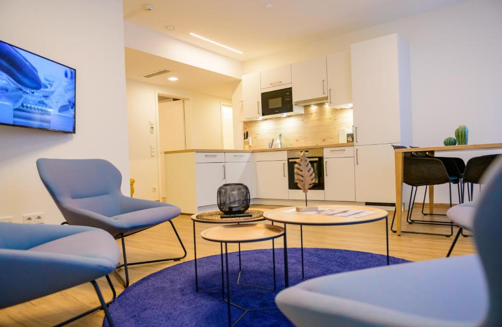 a living room with two chairs and a kitchen at Appart-Hotel Ernz Noire in Grundhof