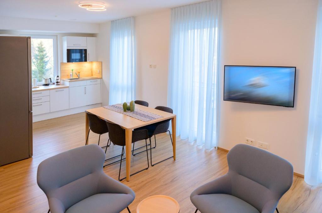 a kitchen and dining room with a table and chairs at Appart-Hotel Ernz Noire in Grundhof