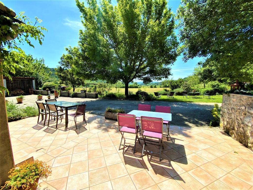 a patio with a table and chairs on a patio at CHAMBRES D&#39;HOTES 2 à 4p ou GITE DE GROUPE 15p, 7 ch, 6 sdb, parc et salle de réception in Villeneuve-de-Berg