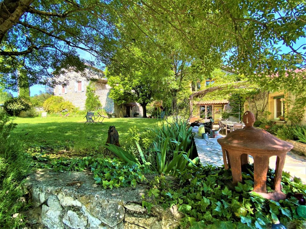 a garden with a statue in the middle of a yard at CHAMBRES D&#39;HOTES 2 à 4p ou GITE DE GROUPE 15p, 7 ch, 6 sdb, parc et salle de réception in Villeneuve-de-Berg