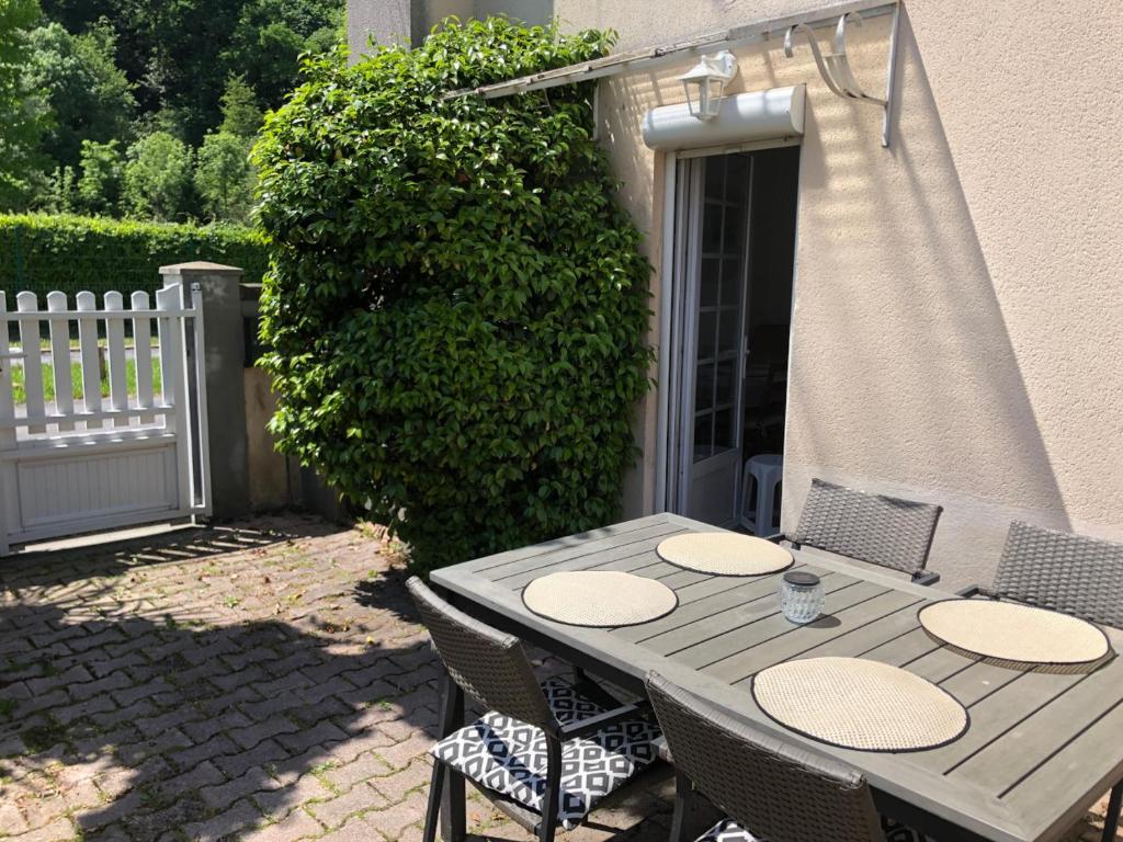 drewniany stół i krzesła na patio w obiekcie Petite maison avec terrasse w mieście Jurançon