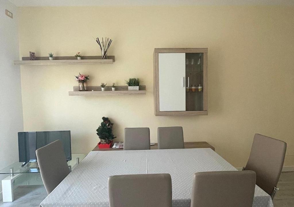 Habitación con mesa, sillas y espejo. en La Magnolia Apartments V Sunflower, en Desenzano del Garda
