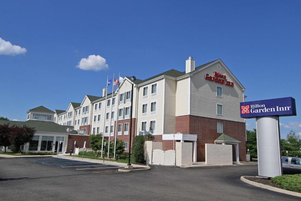 un hotel con un cartel frente a un edificio en Hilton Garden Inn Westbury, en Westbury