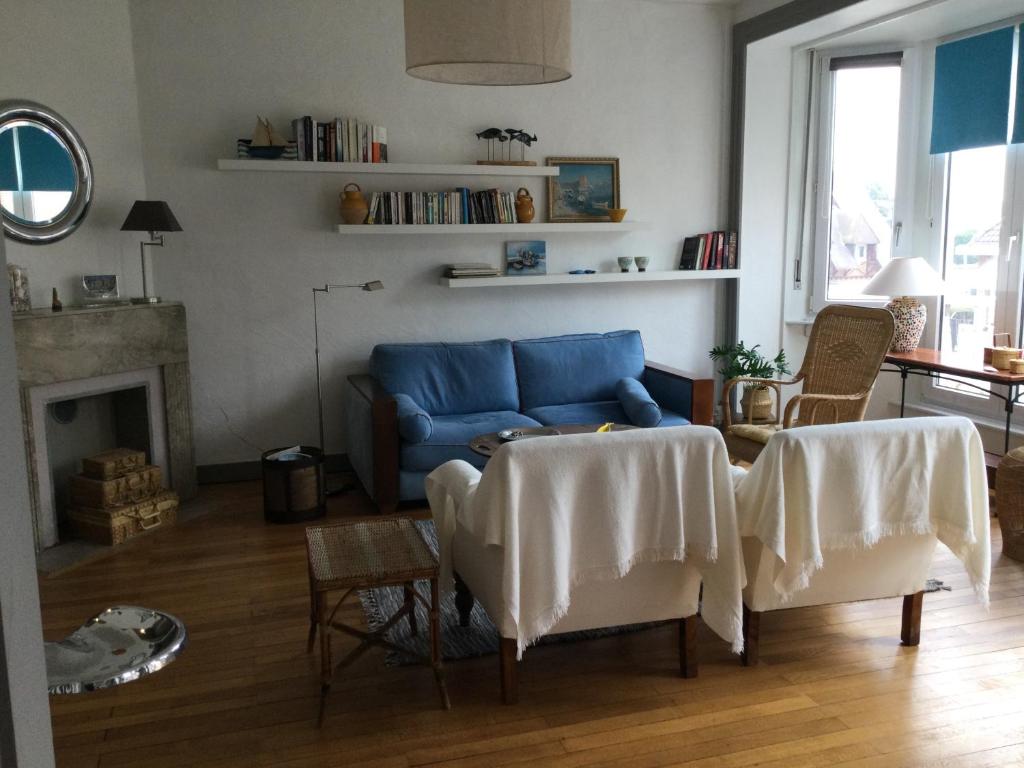 een woonkamer met een blauwe bank en een tafel bij Villa des sables in Duinkerke